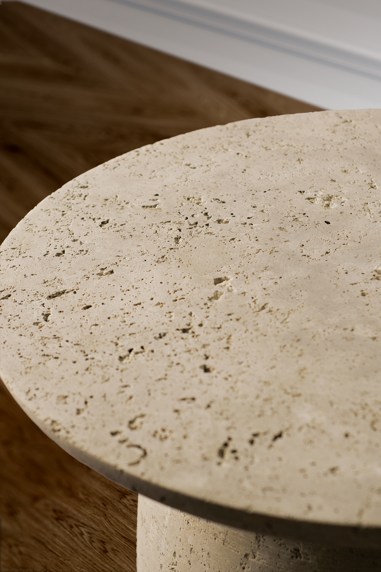 "Sophisticated side table in travertine, showcasing a round top and unique base design."