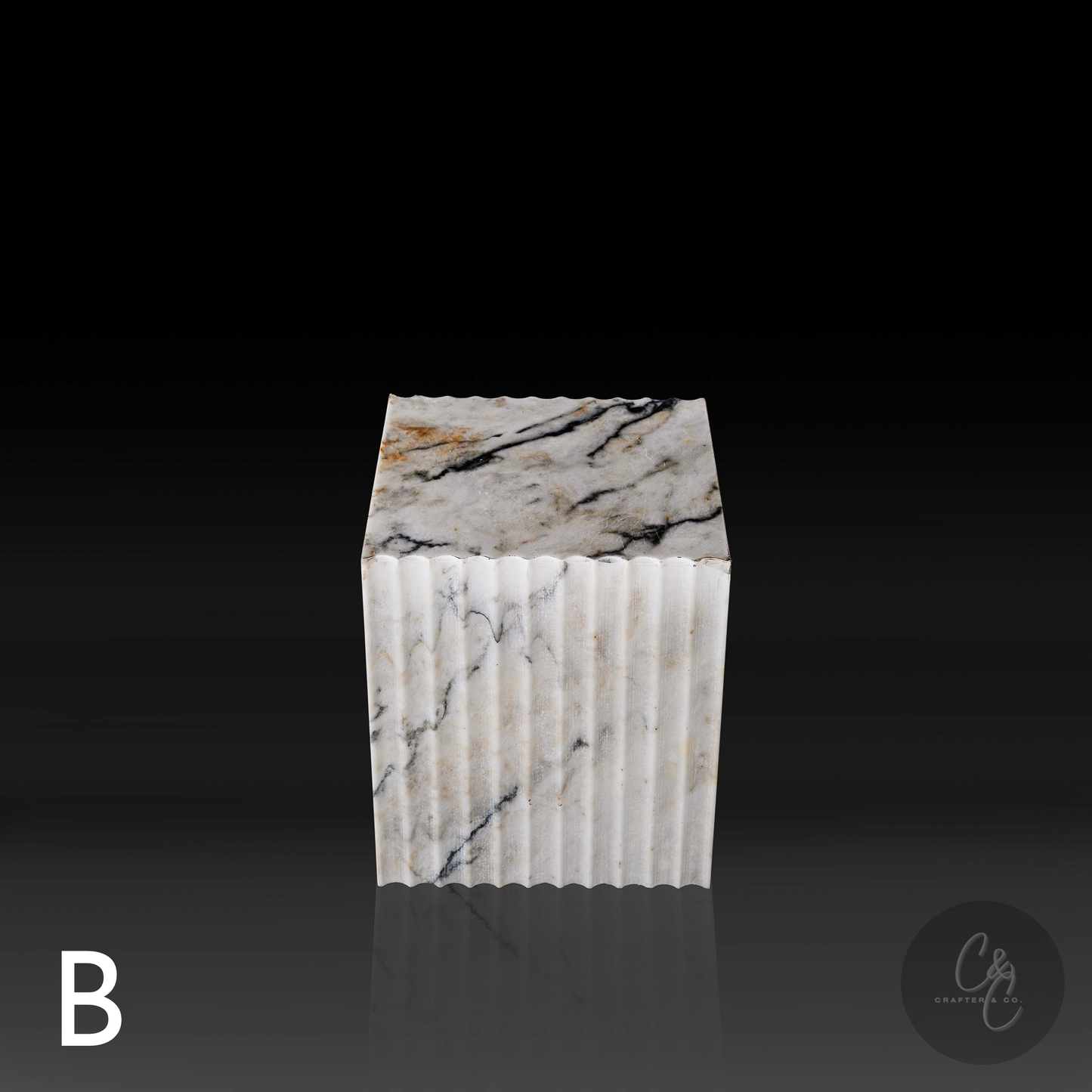 Calacatta Monet marble corrugated cube side table top side view highlighting dramatic veining grey and gold.