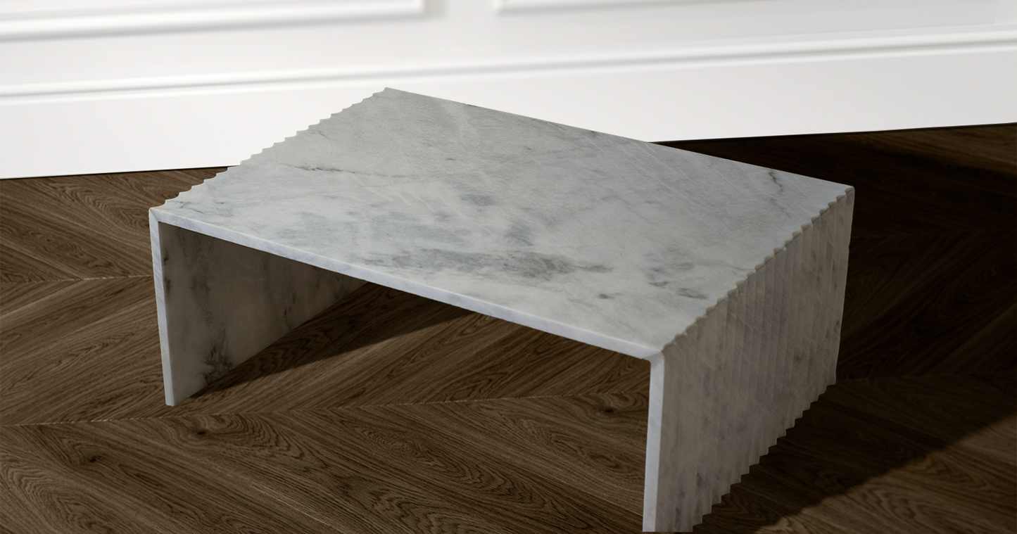 "Stria coffee table showcasing intricate grey veins in white marble and artisanal craftsmanship."