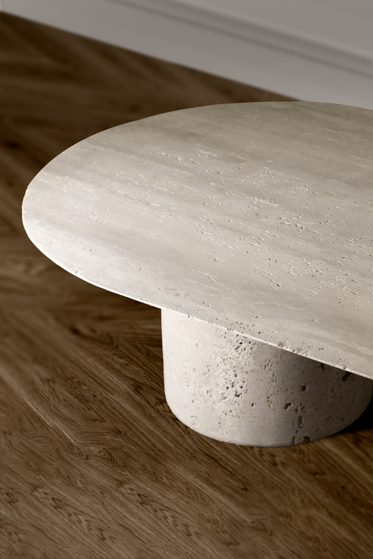 Close-up view of the Harmony Travertine Coffee Table showcasing its natural travertine texture and rounded edge.