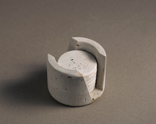 Elegant murmor coasters with matching holder in travertine enhancing a modern bar area.