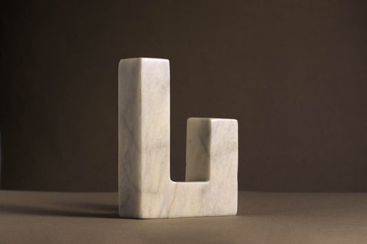 Unique L-shaped candle holder in white marble highlighting its natural beauty and texture.
