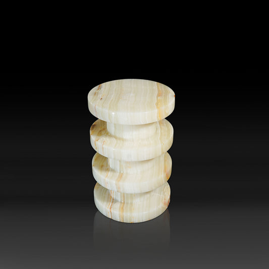 Side profile of the Vela White Onyx Side Table showcasing its sculptural stacked design in natural white onyx.