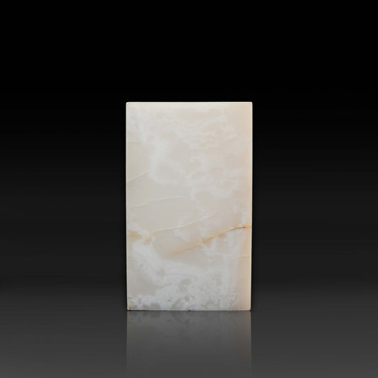 Front view of the handcrafted White Onyx column side table with polished finish and natural golden veining.