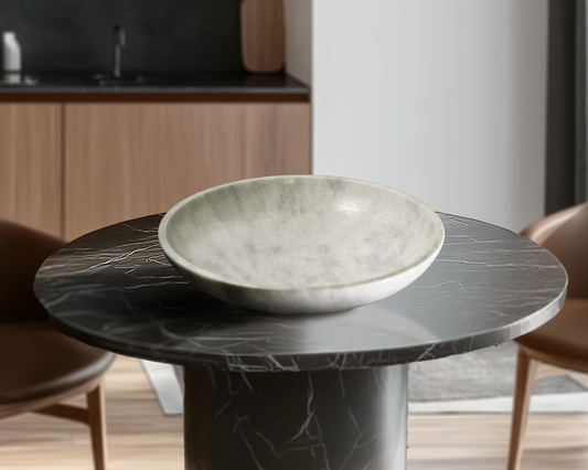 Grande White Marble Decorative Bowl styled as a luxury centerpiece on a black marble table in a contemporary living space.
