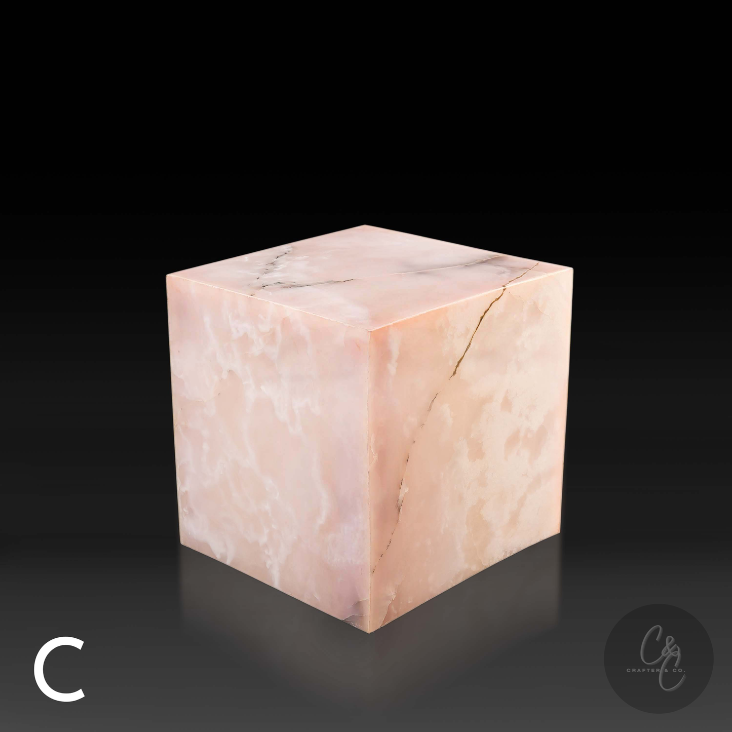 Pink onyx cube side table variation C shown from a top angle, highlighting its polished surface and delicate natural veining.
