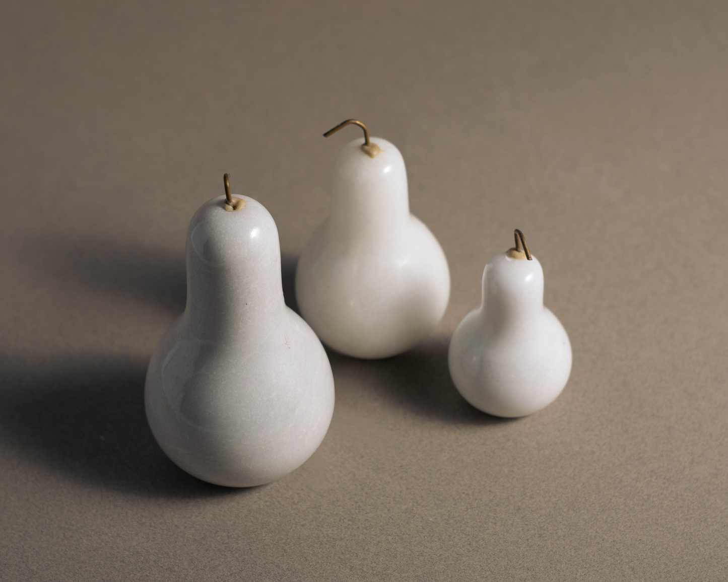 Three handcrafted white marble pears decorative set for modern luxury home styling.