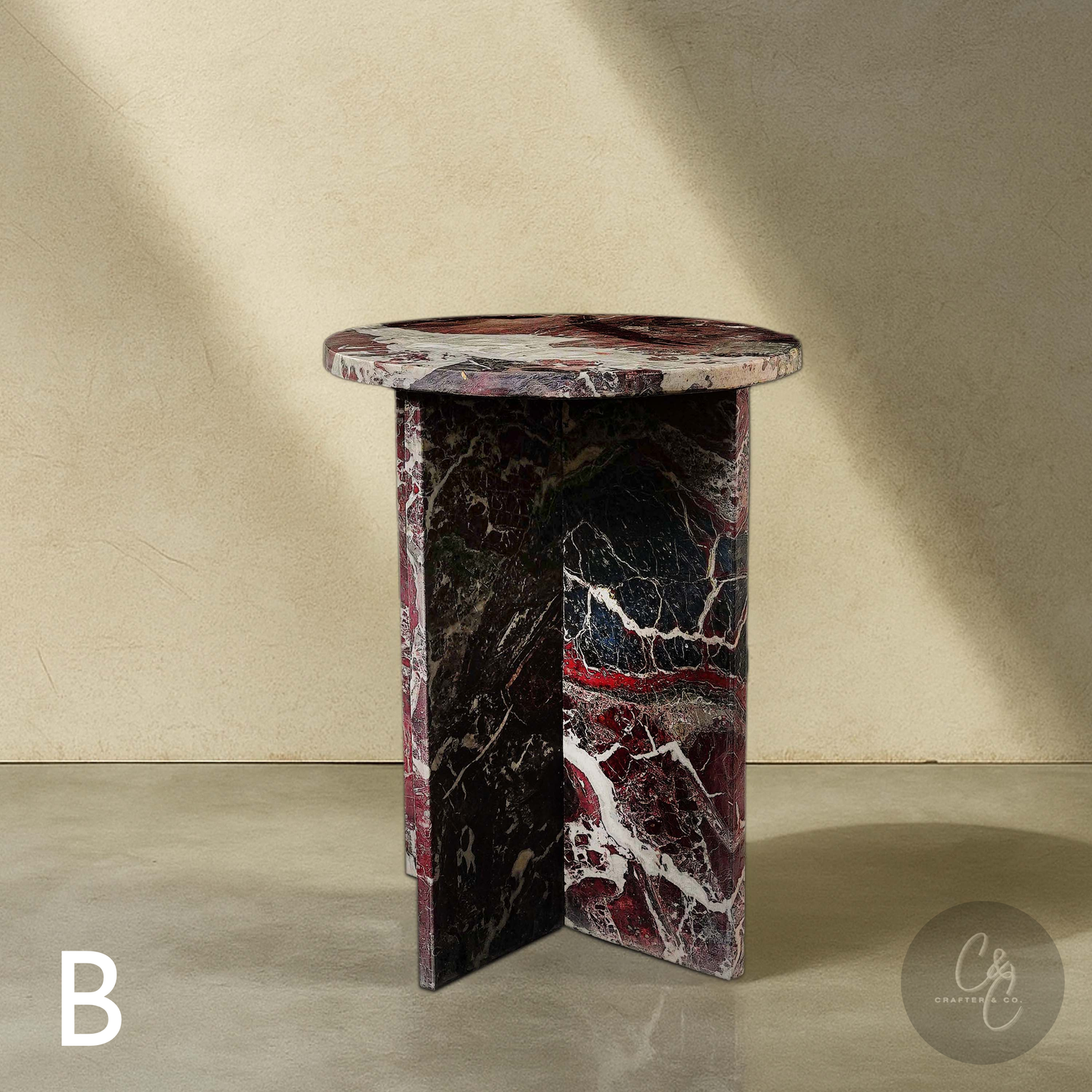 Round Cross Rosso Levanto marble side table with honed finish in studio setting