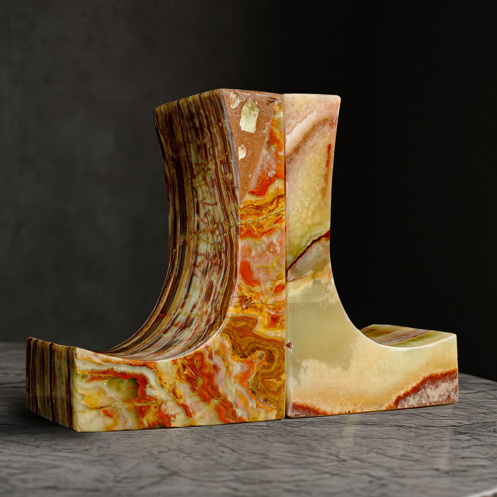 Front angle of Ascend Green Onyx bookends crafted from natural polished onyx displayed on a stone surface.