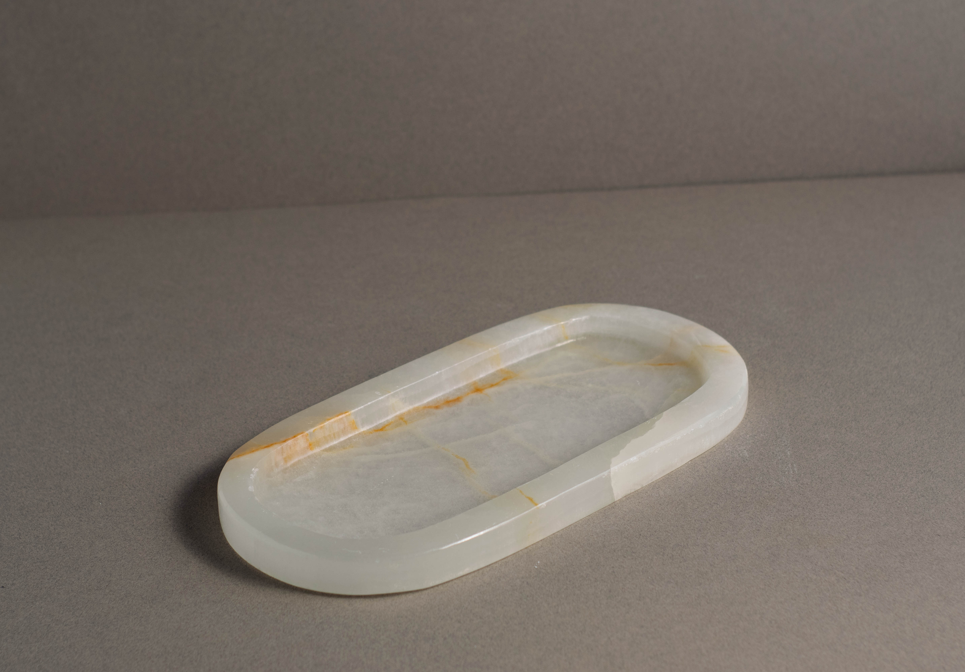 Aura White Onyx Tray styled on a coffee table in a contemporary interior.