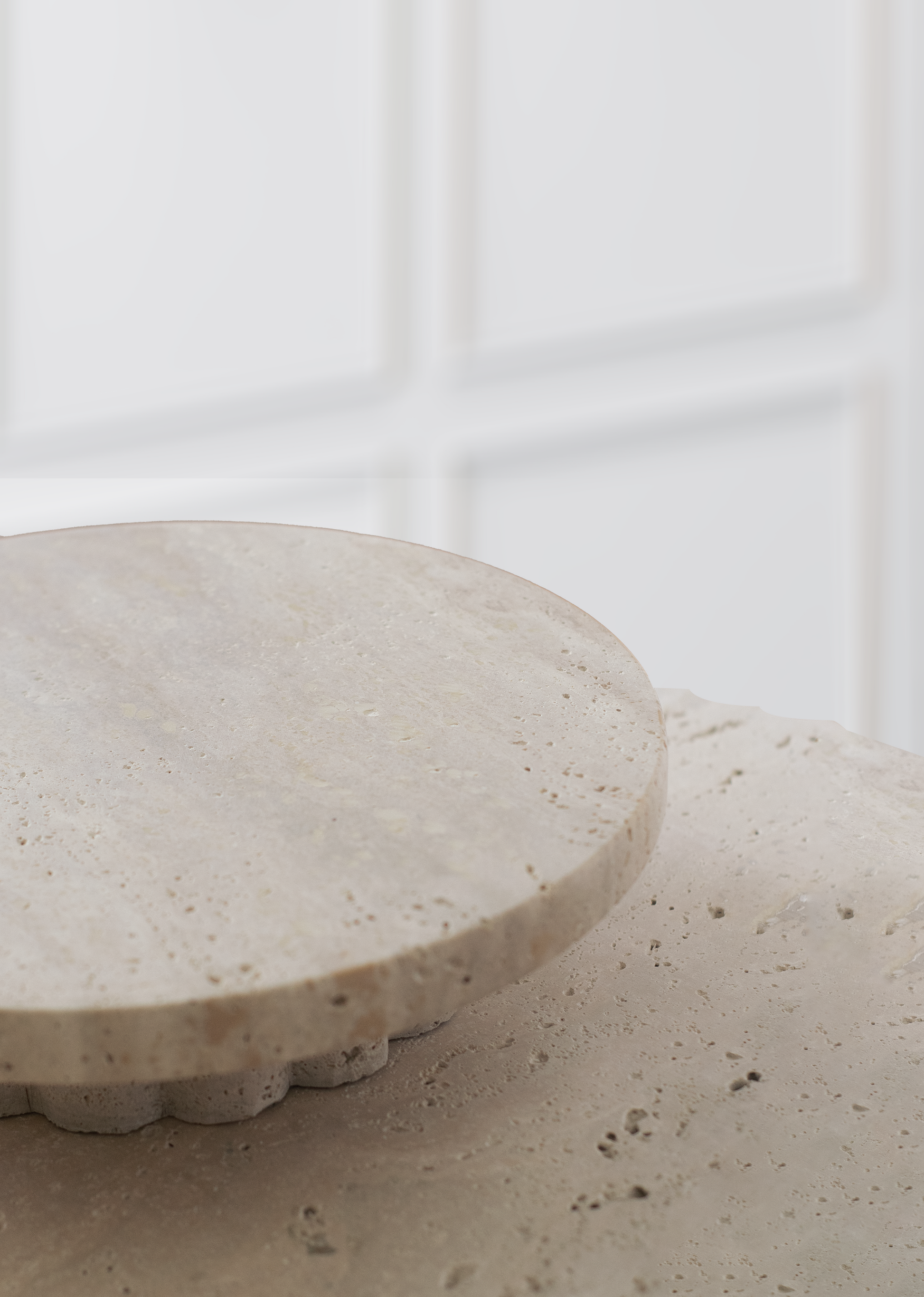 Column Travertine Round Tray styled on a coffee table in a contemporary interior.