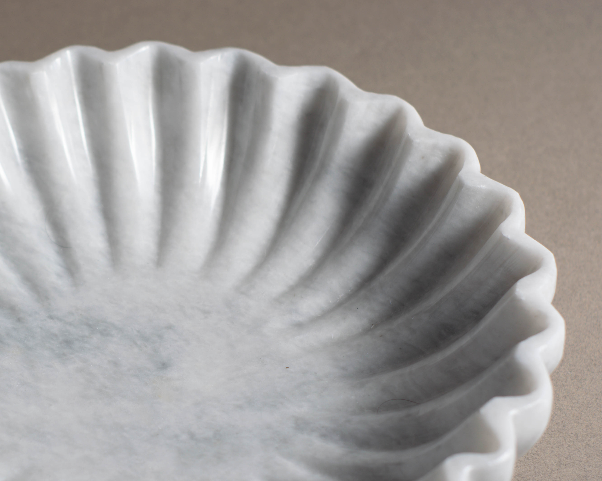 Close-up of the Coral White Marble Bowl highlighting the natural marble veining and sculptural fluted texture.