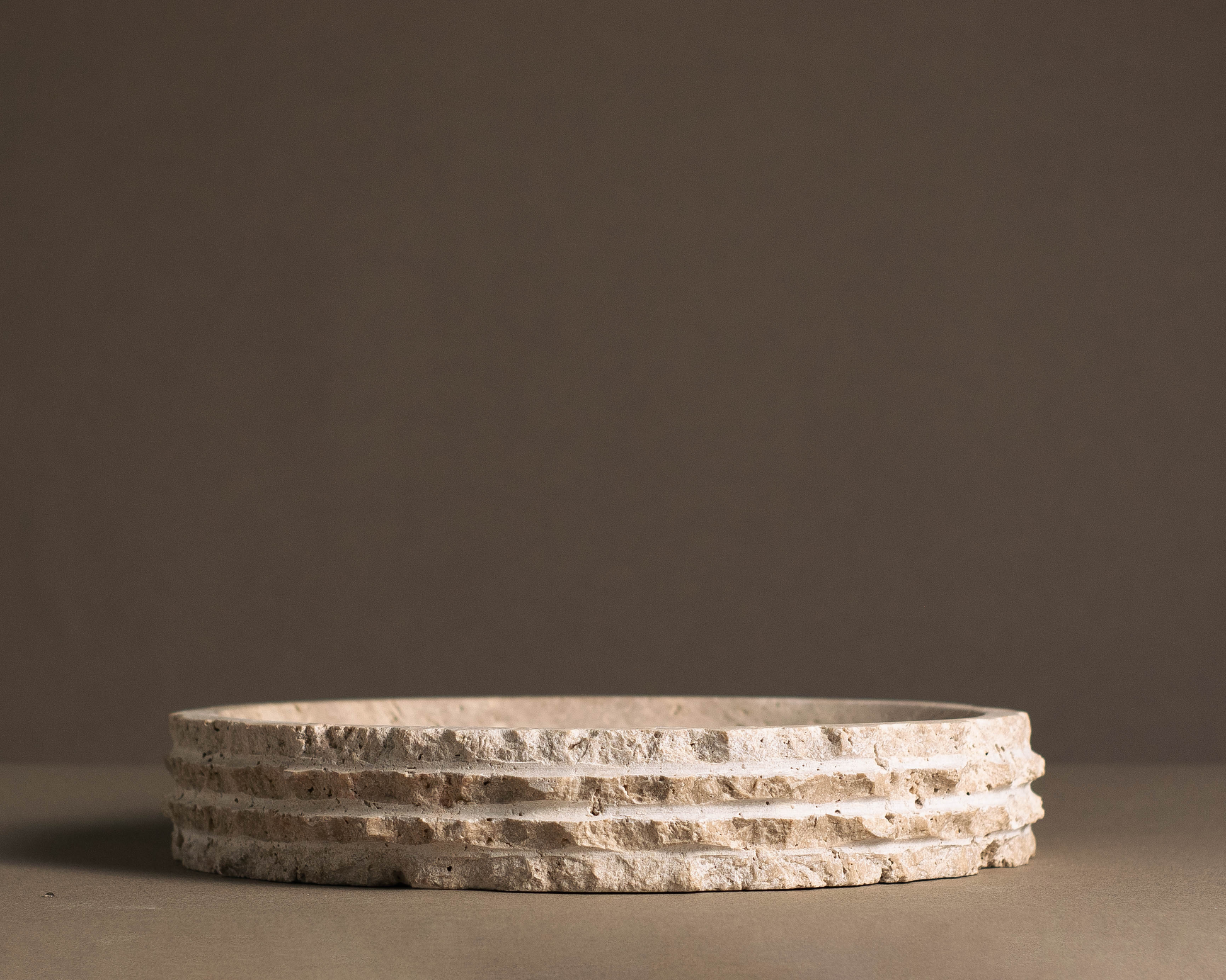 Eclipse Travertine Bowl handcrafted from natural travertine featuring a layered sculptural edge and warm earthy tones.