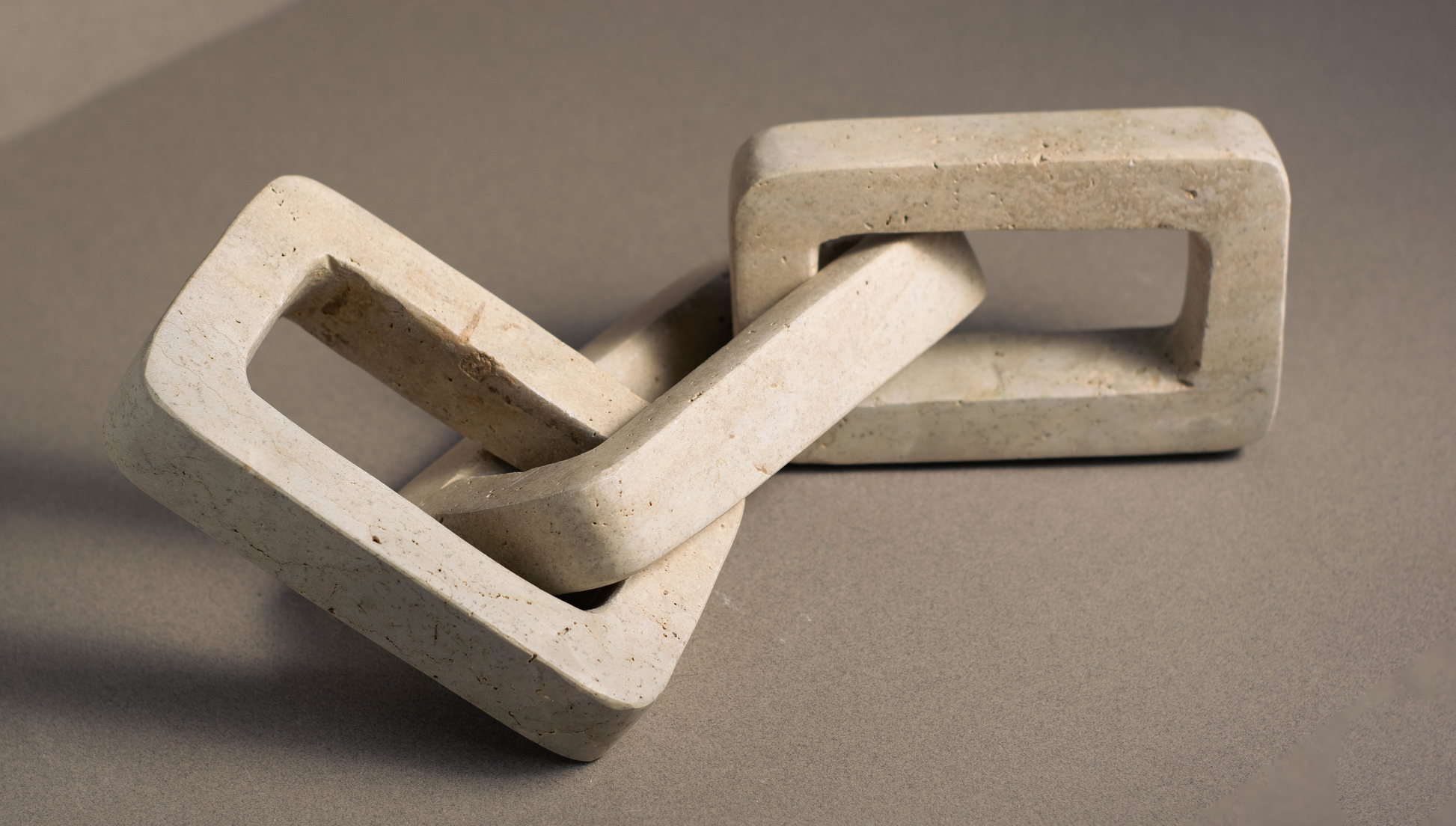 Hand carved travertine chain link made from one solid piece of natural stone.
