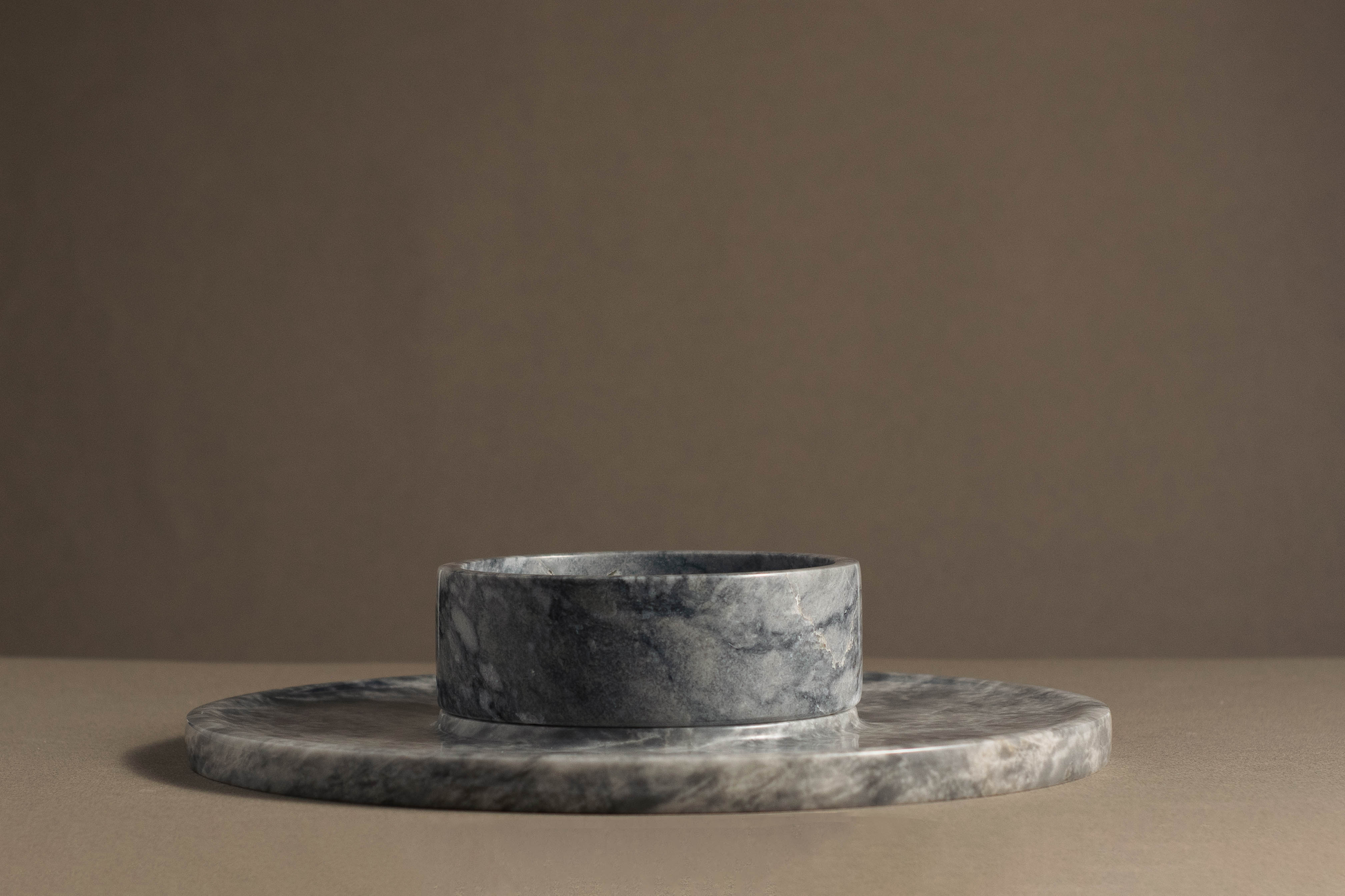 Angled view of Grey Marble Round Cheese Platter with marble bowl.