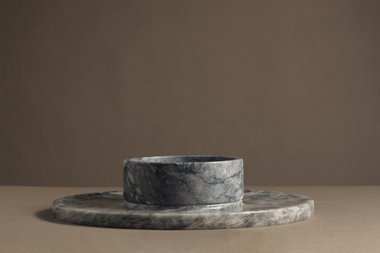 Angled view of Grey Marble Round Cheese Platter with marble bowl.