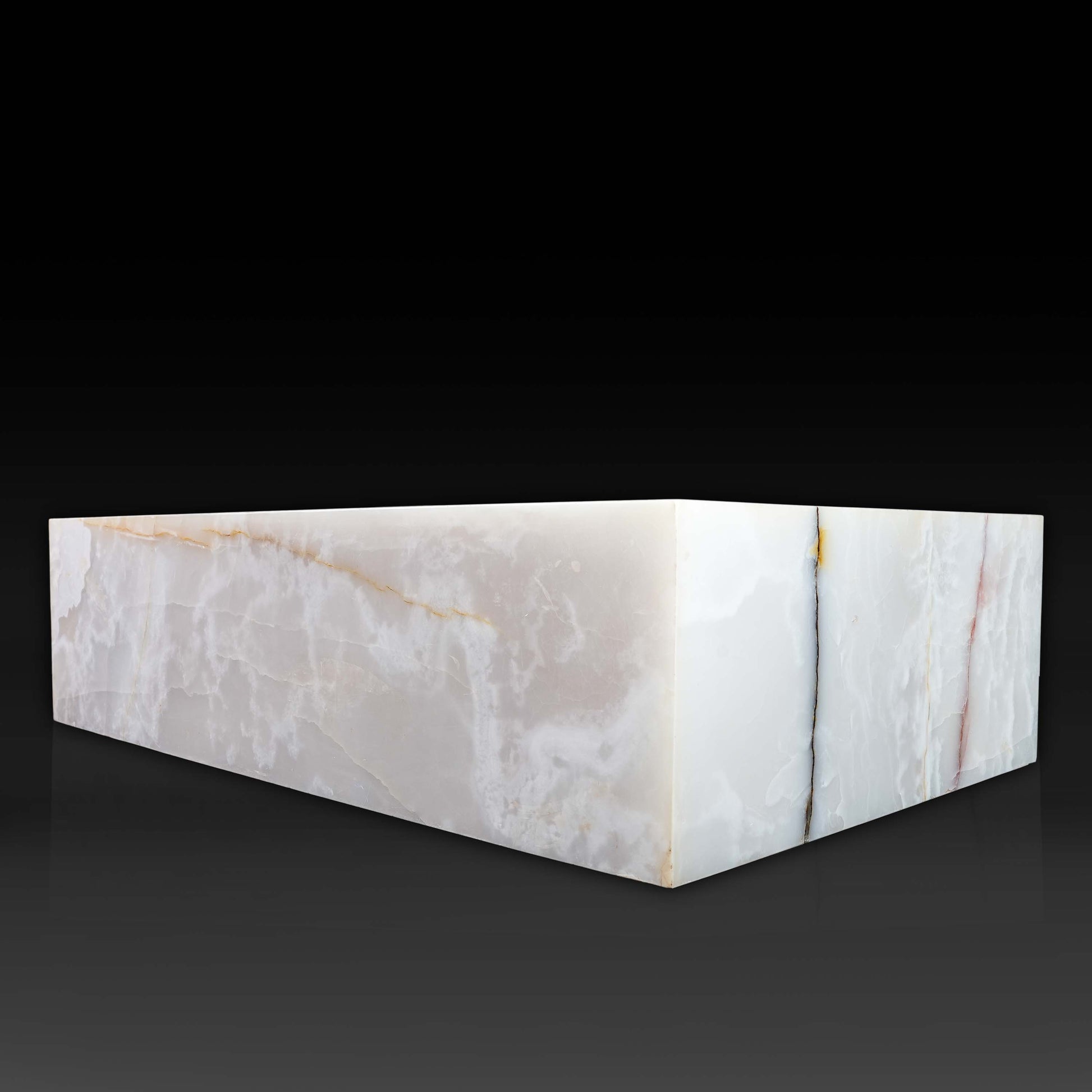 Angled view of large White Onyx block coffee table with polished natural stone finish