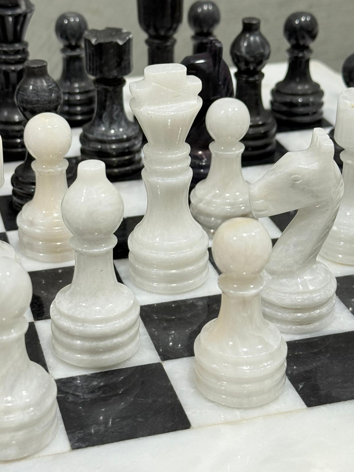 Close-up of marble chess pieces on a checkered board