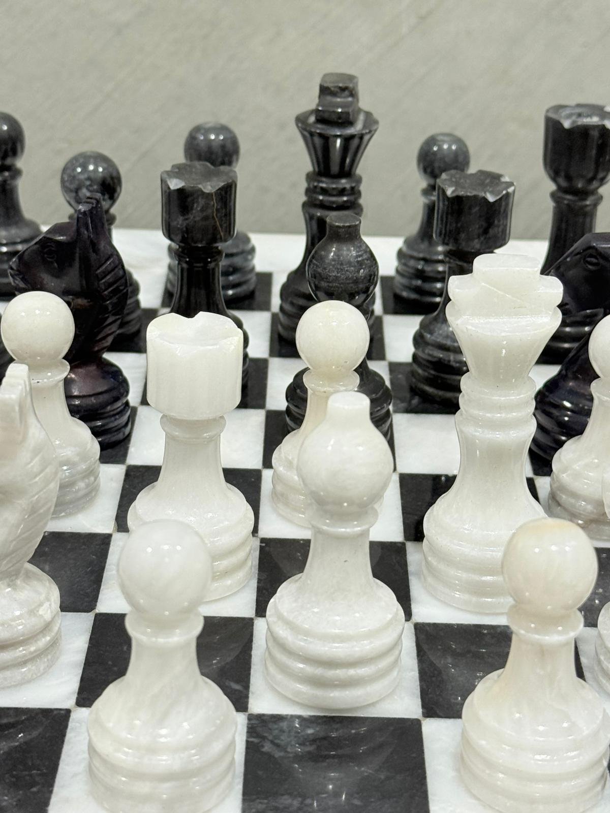 Close-up of a chessboard with black and white pieces.