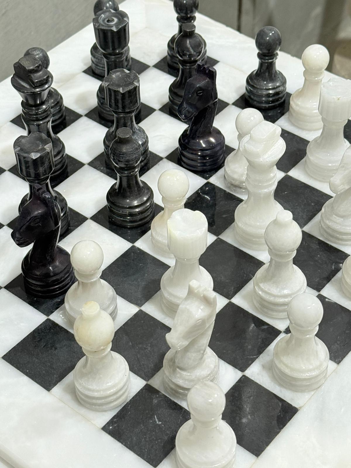 Close-up of a chessboard with black and white pieces.