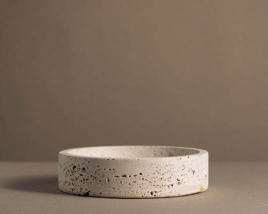 Side view of the Orb Travertine Round Bowl highlighting its handcrafted natural travertine texture and minimalist profile.