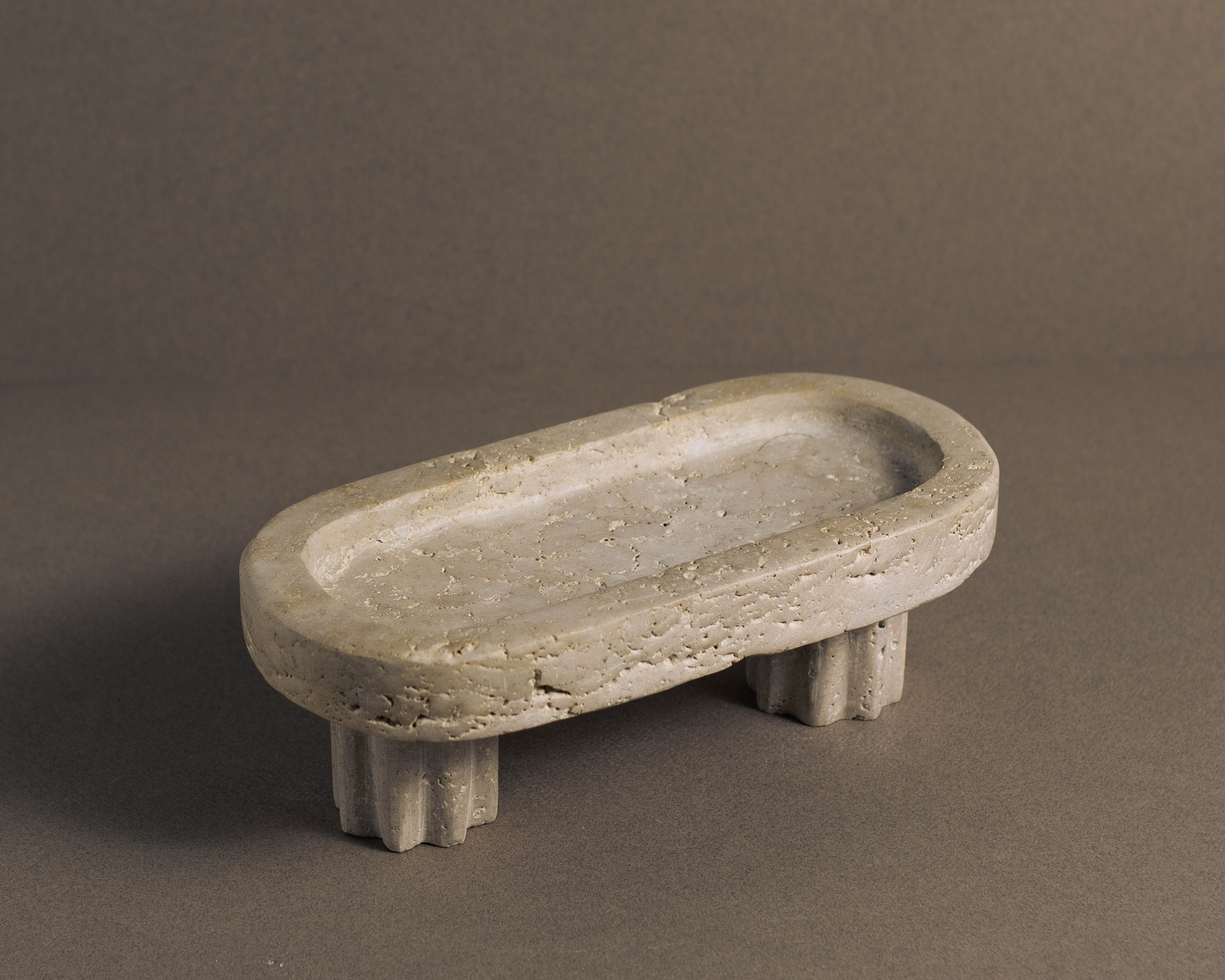 Oval Travertine Column Tray handcrafted from natural travertine shown from a front angle.
