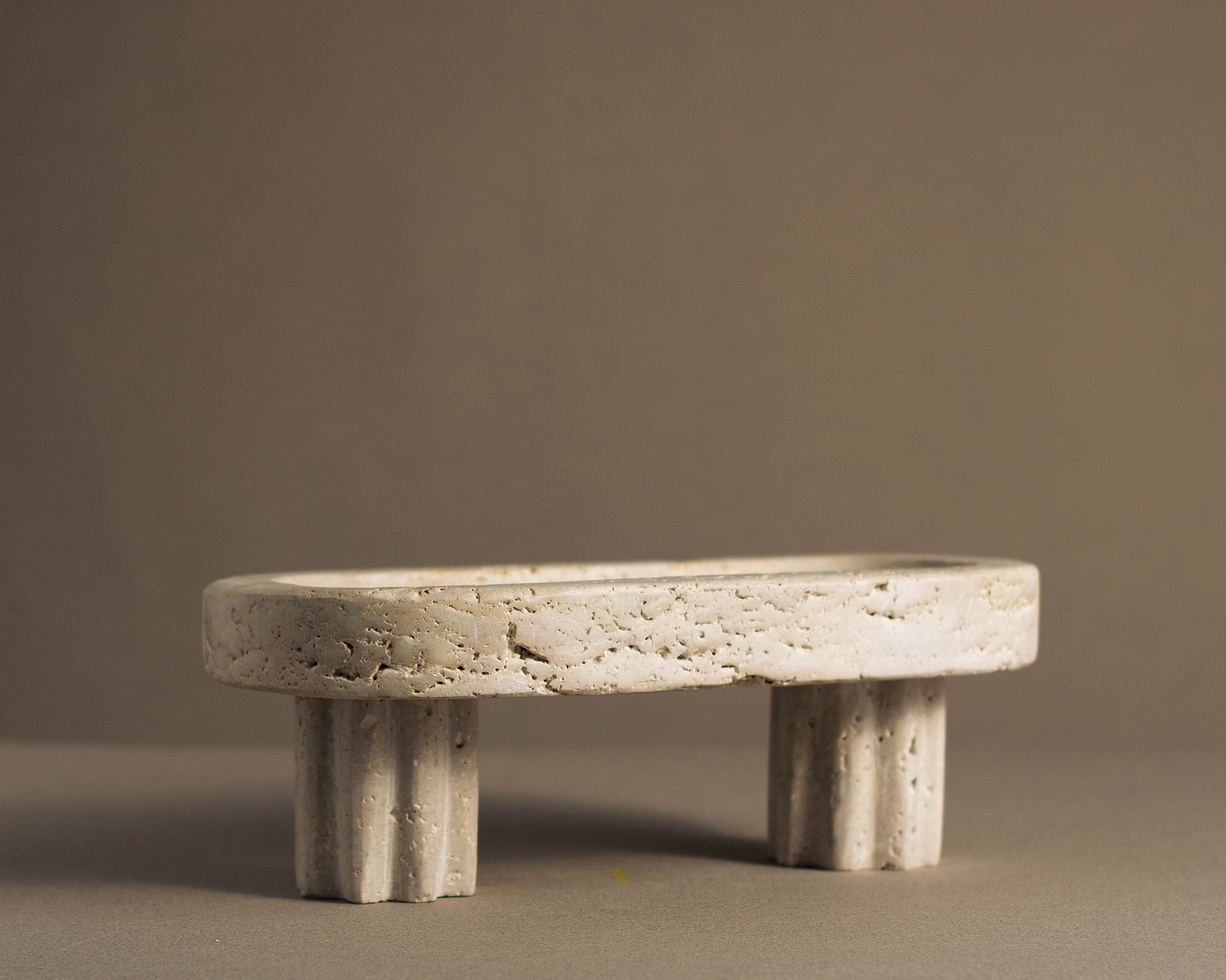 Oval Travertine Column Tray handcrafted from natural travertine with sculptural column base front view.