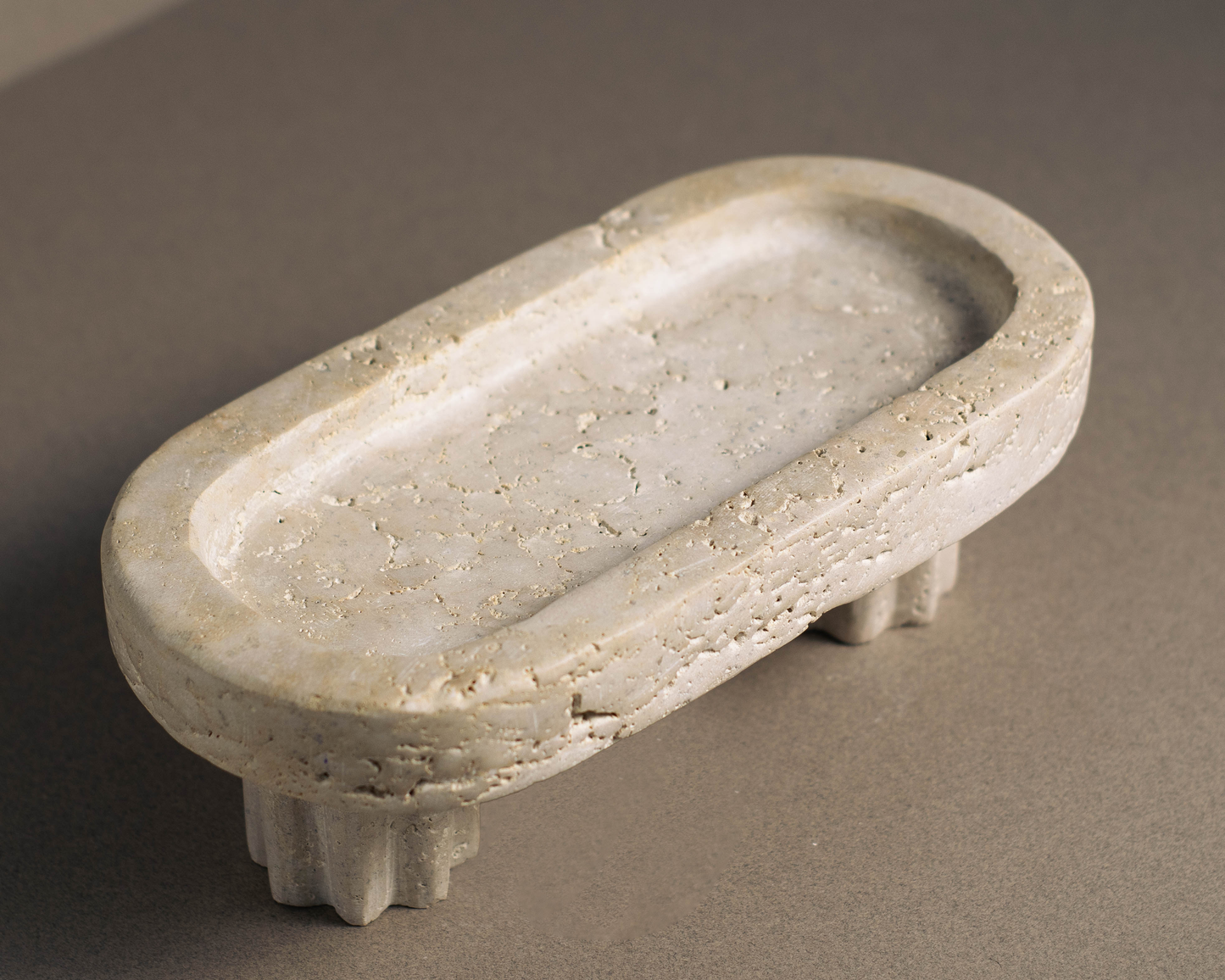 Oval Travertine Column Tray handcrafted from natural travertine shown from a top angle.