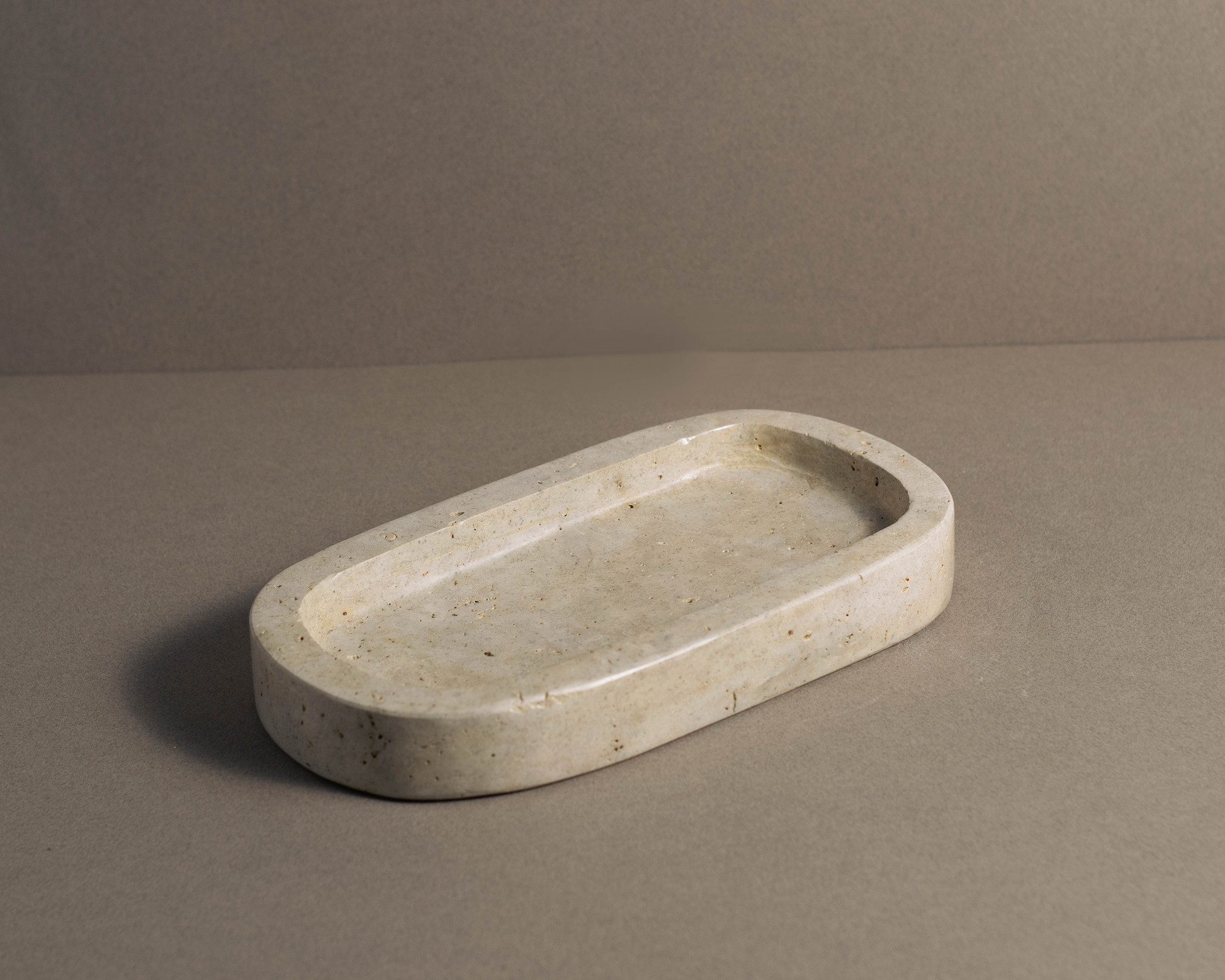 Oval Travertine Tray viewed from a top angle highlighting natural stone texture and organic shape.