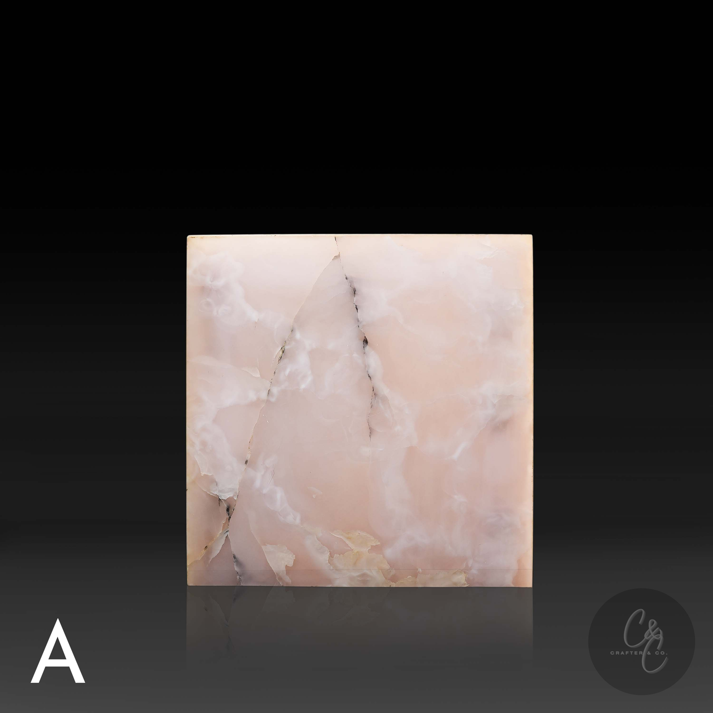 Pink onyx cube side table variation A shown from the front, featuring soft blush coloring and distinctive natural veining.