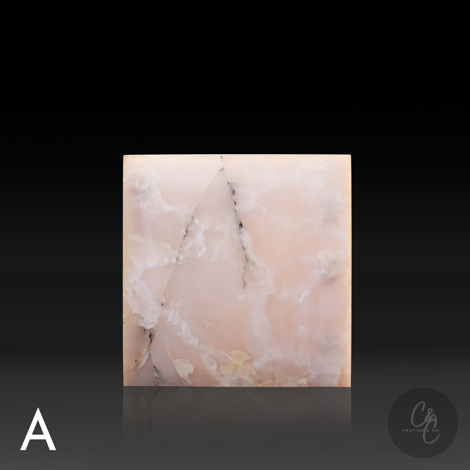 Pink onyx cube side table variation A shown from the front, featuring soft blush coloring and distinctive natural veining.