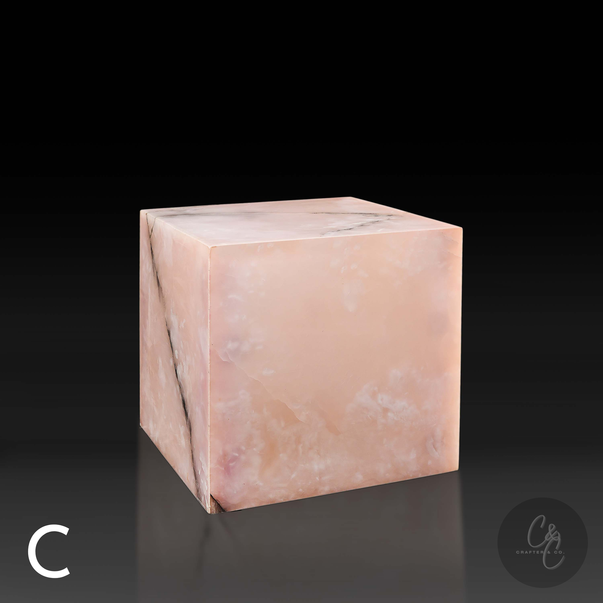 Pink onyx cube side table variation C shown from the front profile, highlighting its translucent blush coloring.