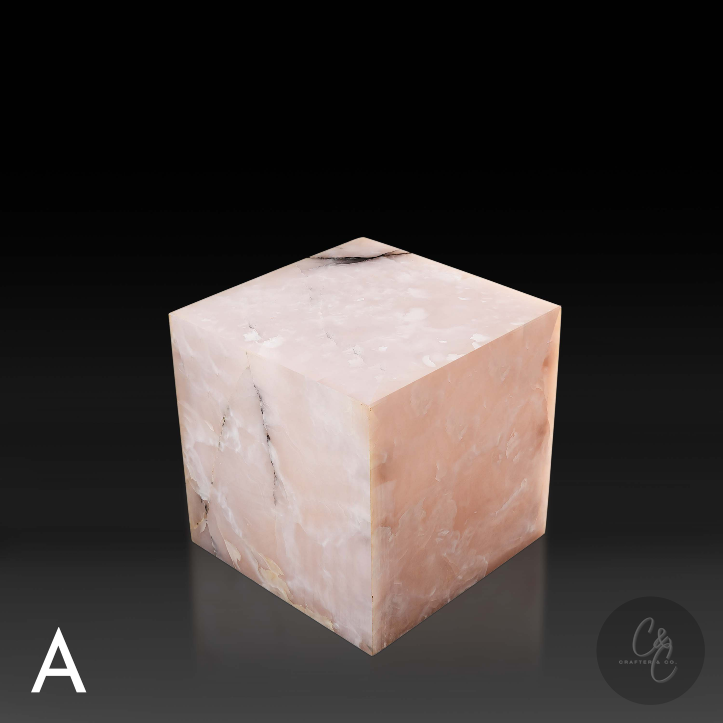 Pink onyx cube side table variation A shown from a top angle, highlighting its polished surface and natural stone pattern.