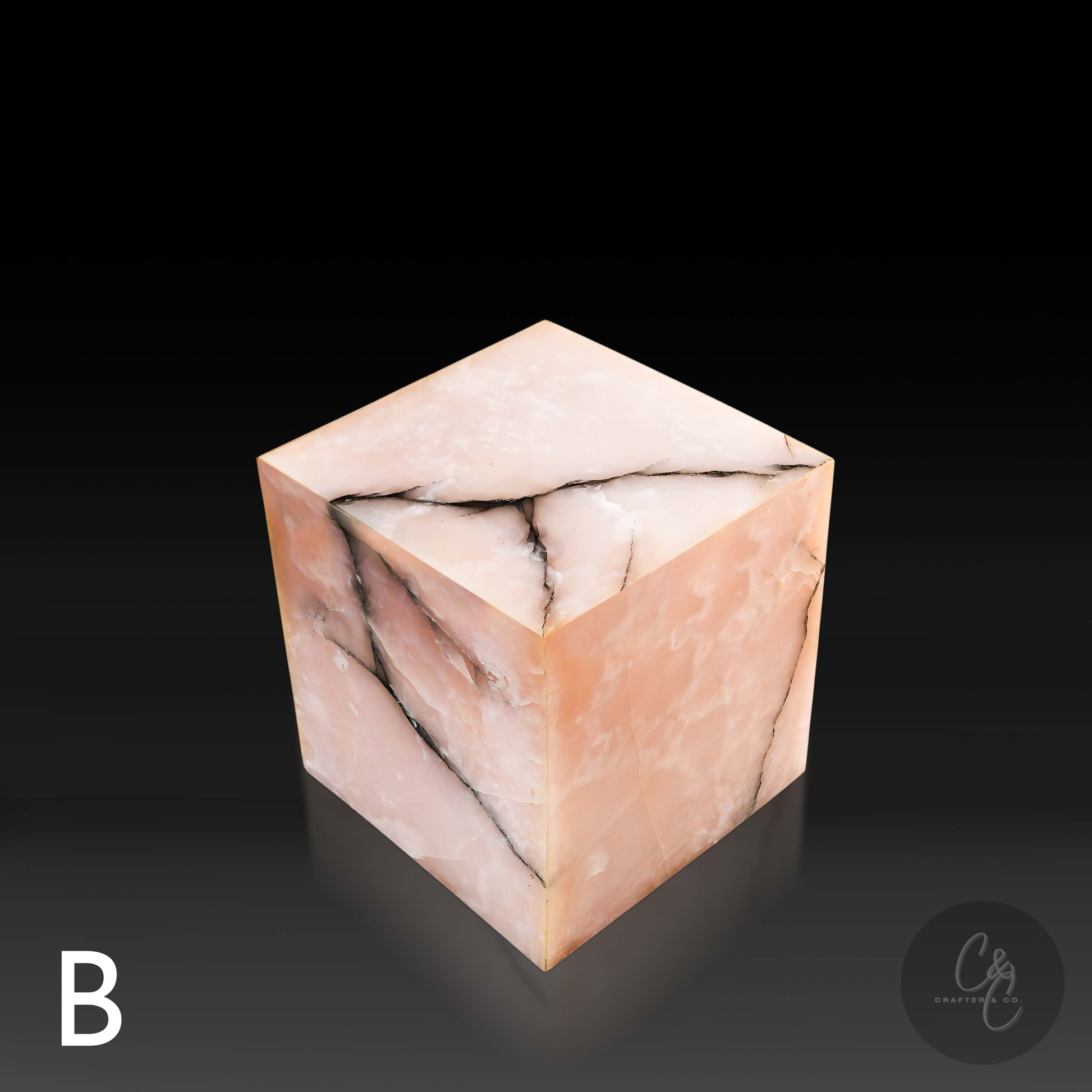 Pink onyx cube side table variation B shown from a top angle, highlighting its polished surface and bold natural veining.