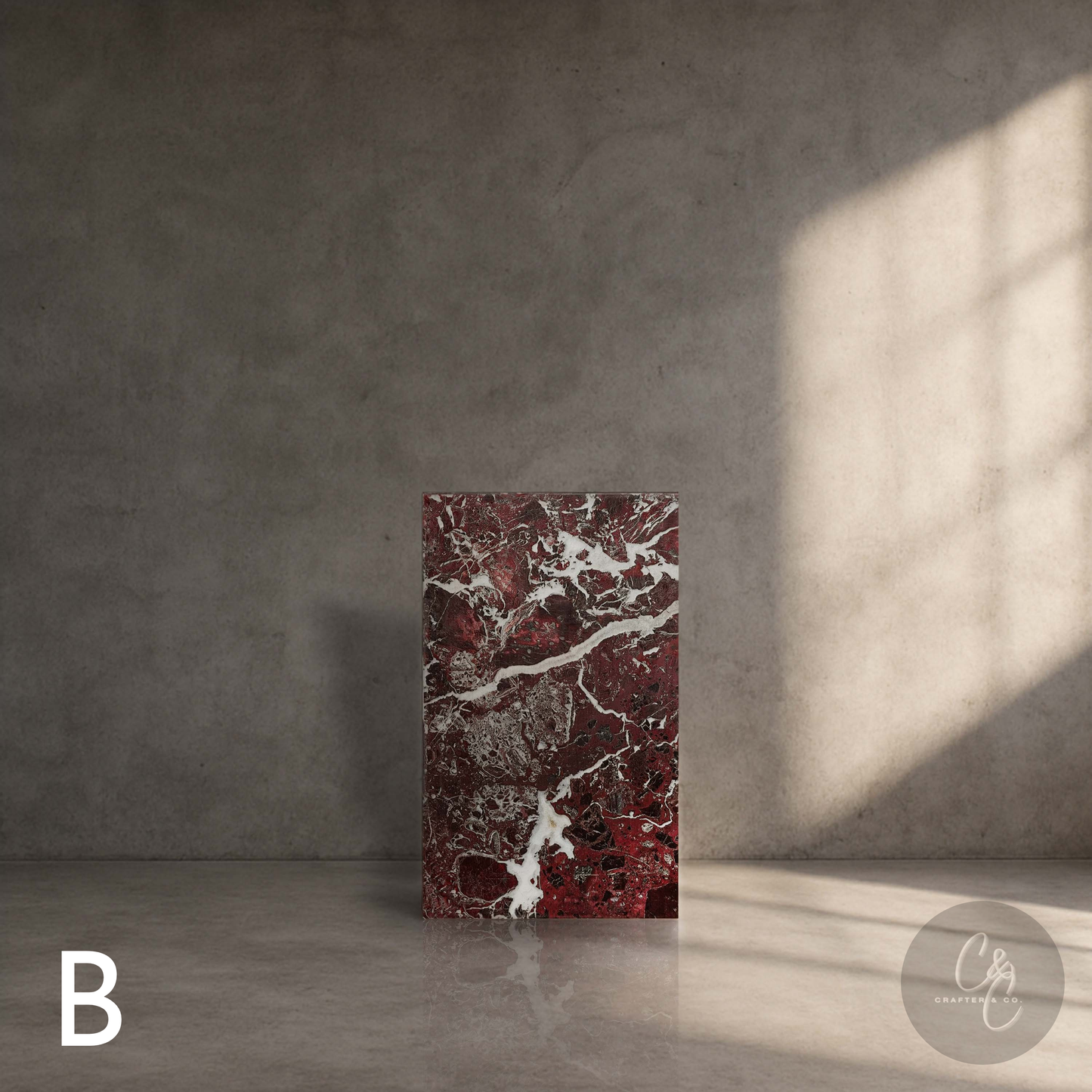Rosso Levanto marble column side table with bold burgundy veining displayed in a refined contemporary interior.