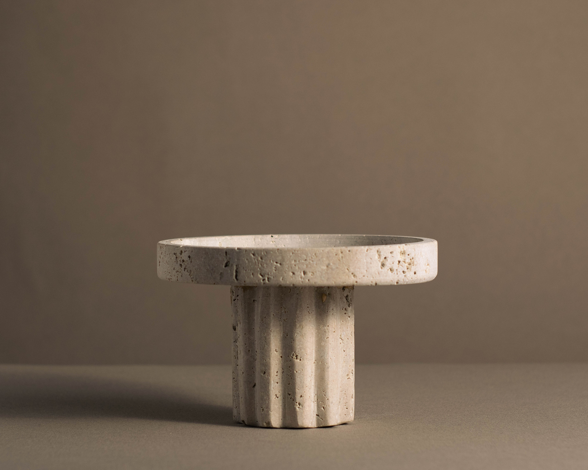 Round Travertine Pedestal Tray handcrafted from natural travertine with sculptural pedestal base.