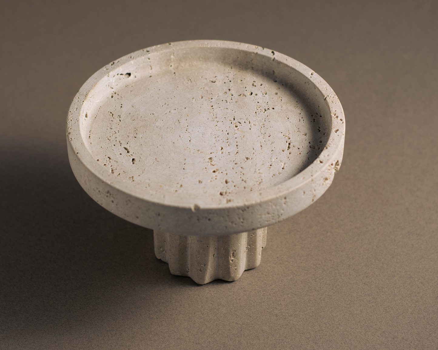 Round Travertine Pedestal Tray viewed from a top angle showcasing natural stone texture and pedestal base.