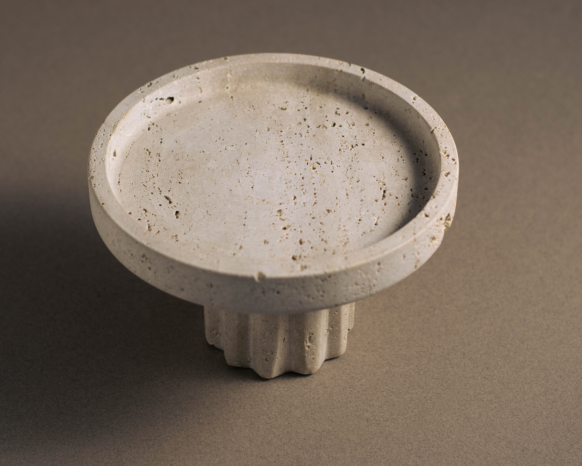 Round Travertine Pedestal Tray viewed from a top angle showcasing natural stone texture and pedestal base.