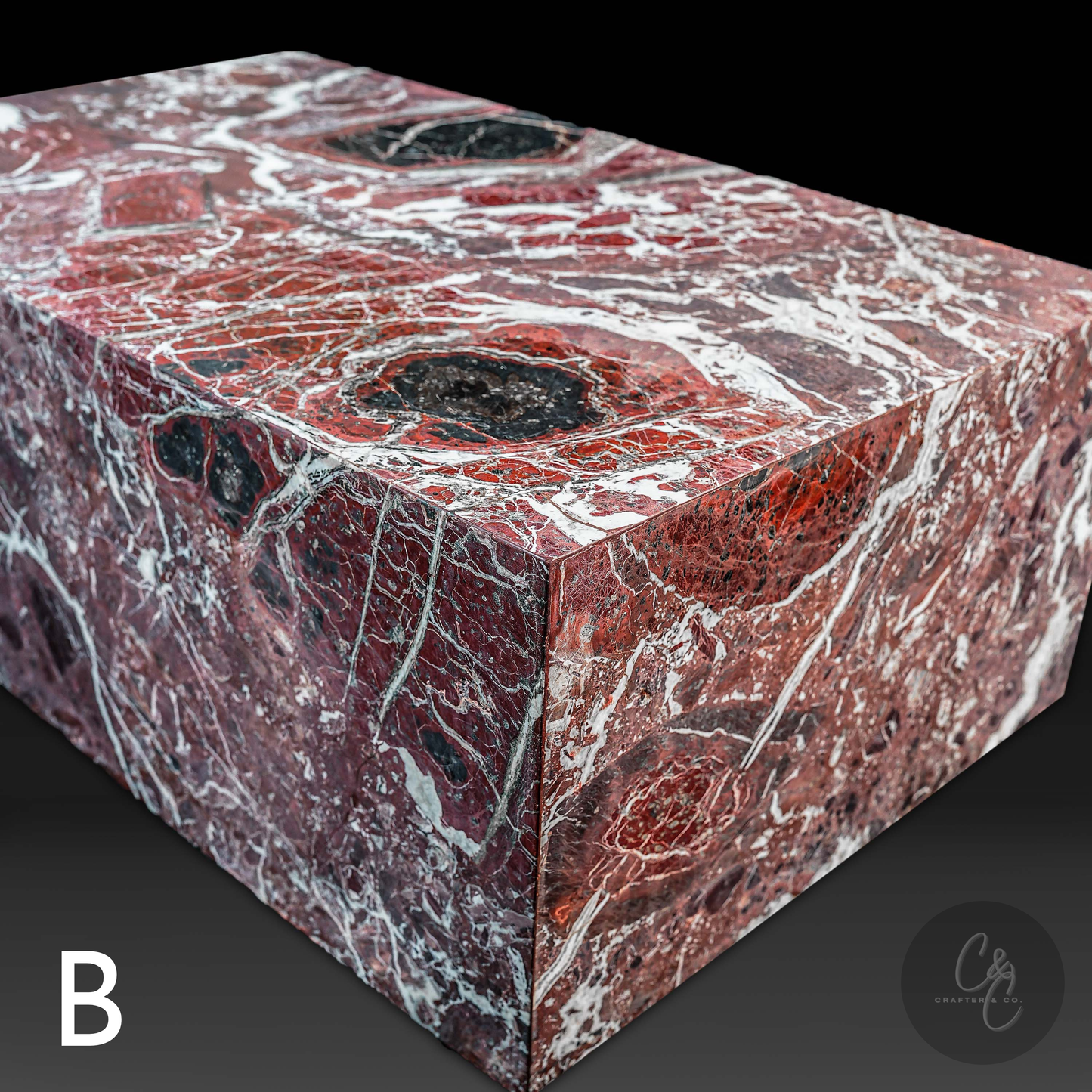 Angled view of Small Block Rosso Levanto Marble Coffee Table Variant B showcasing rich burgundy marble with bold white veining and natural black accents