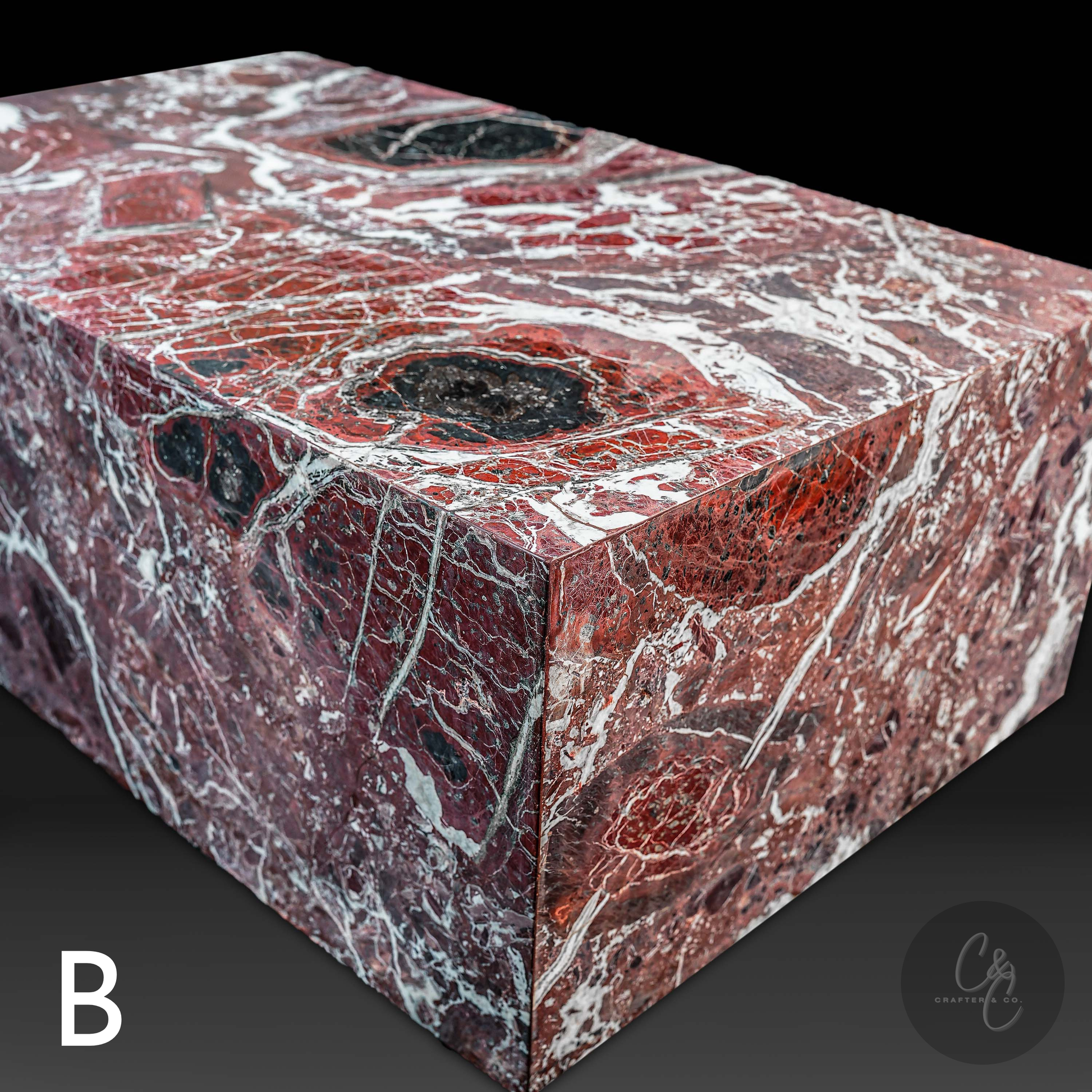 Angled view of Small Block Rosso Levanto Marble Coffee Table Variant B showcasing rich burgundy marble with bold white veining and natural black accents