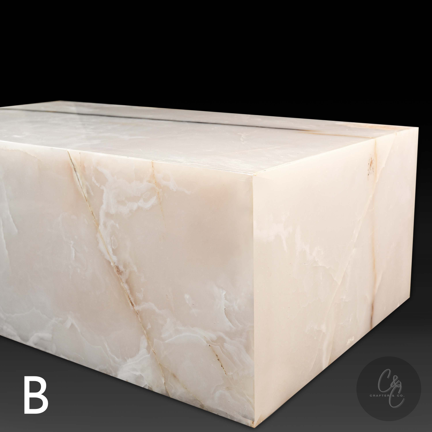Angled view of Small Block White Onyx Coffee Table Variant B highlighting polished natural white onyx with soft ivory tones and golden veining