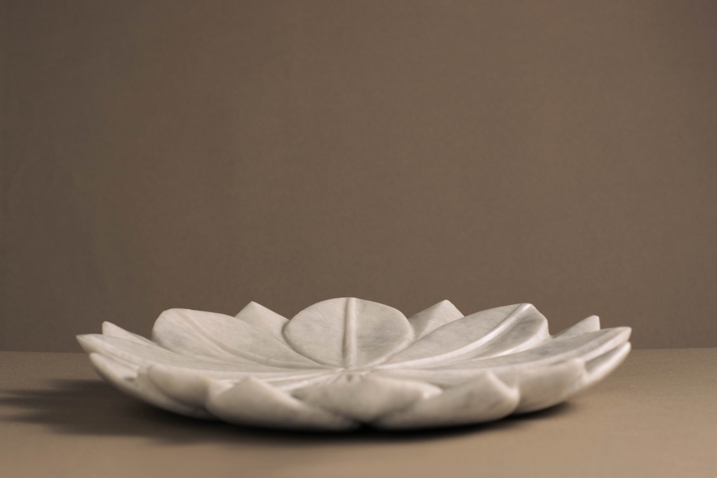 Side profile of the White Marble Lotus Bowl highlighting its sculptural lotus design.