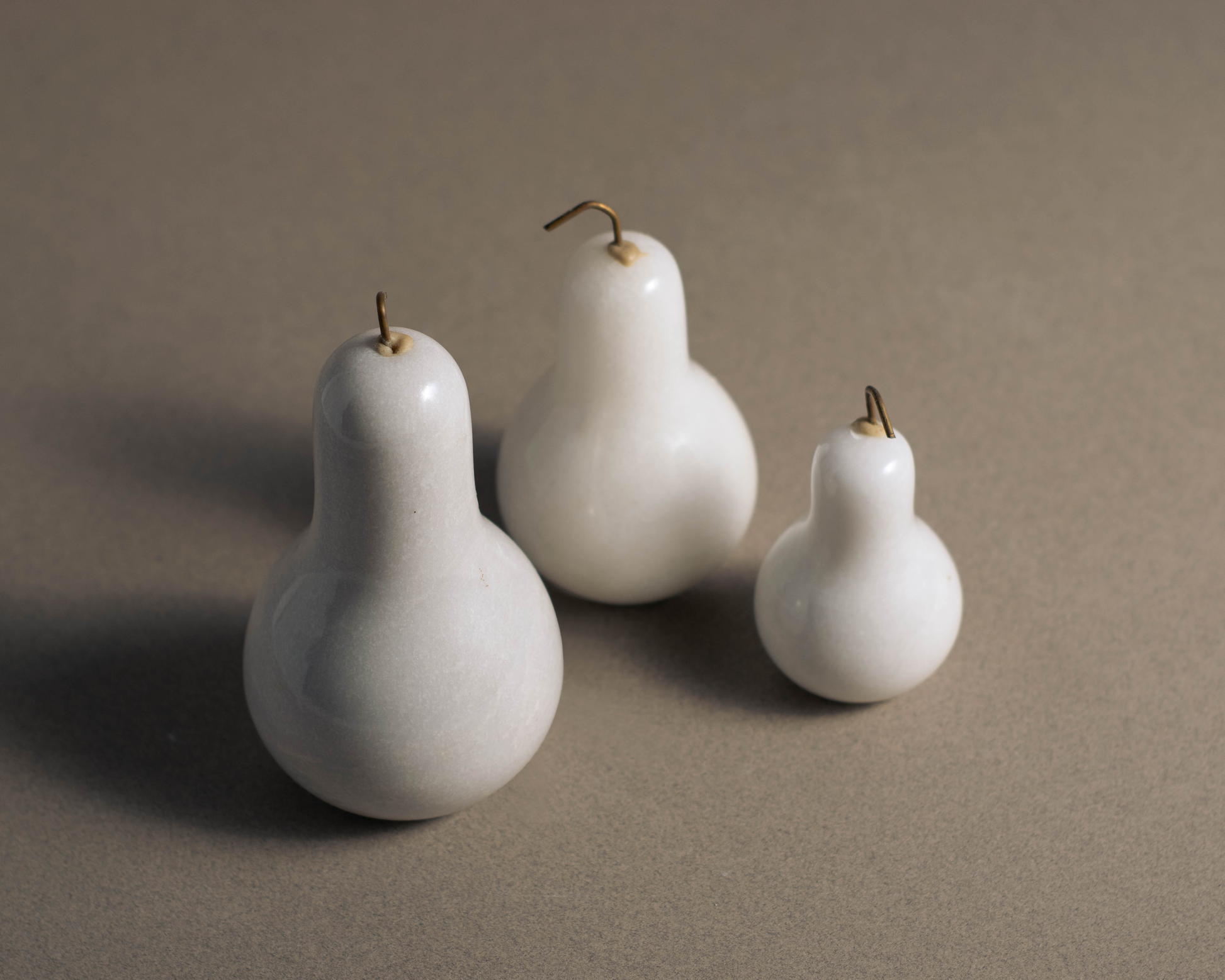 Three handcrafted white marble pears decorative set for modern luxury home styling.