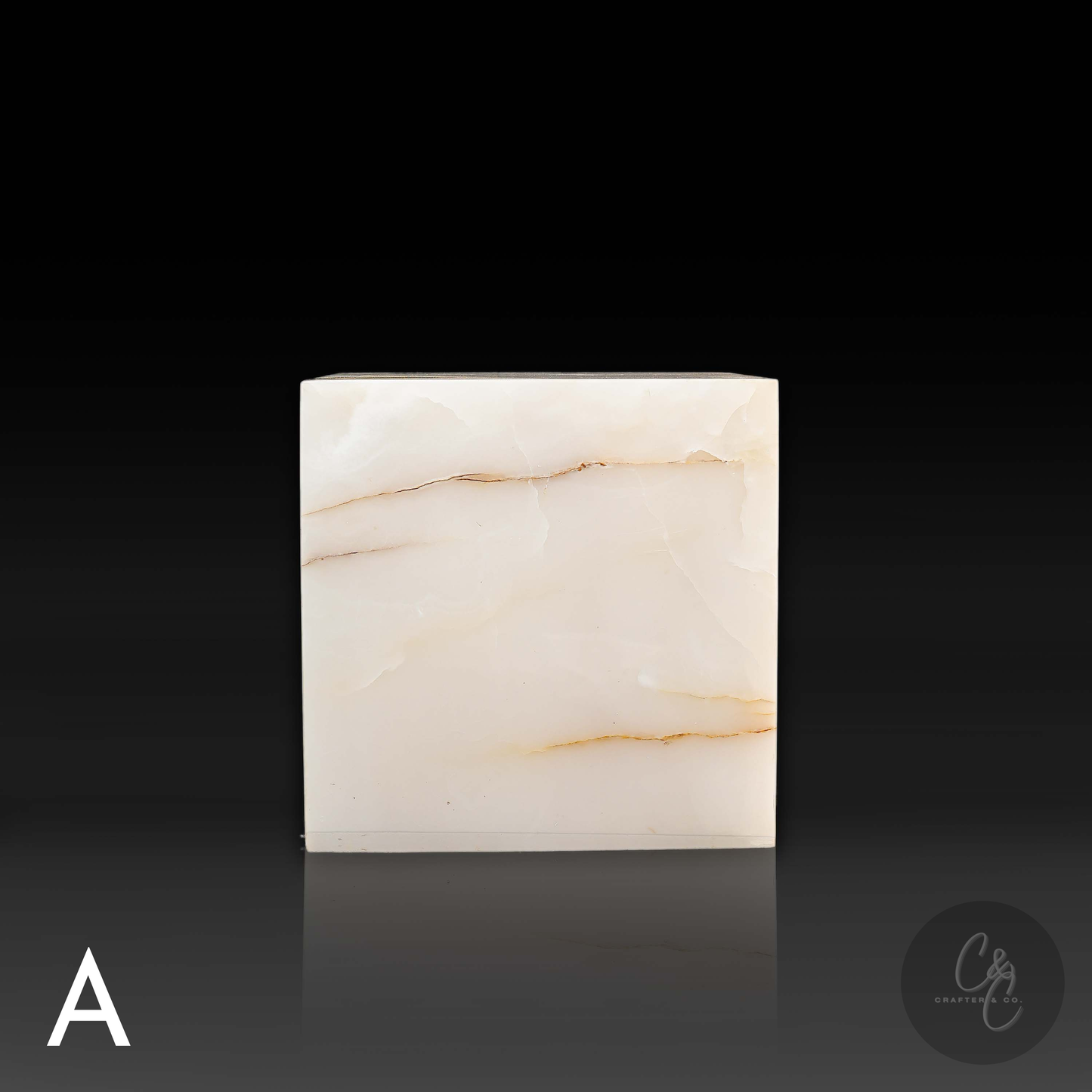White onyx cube side table variation A shown from the front, featuring distinctive natural golden veining.