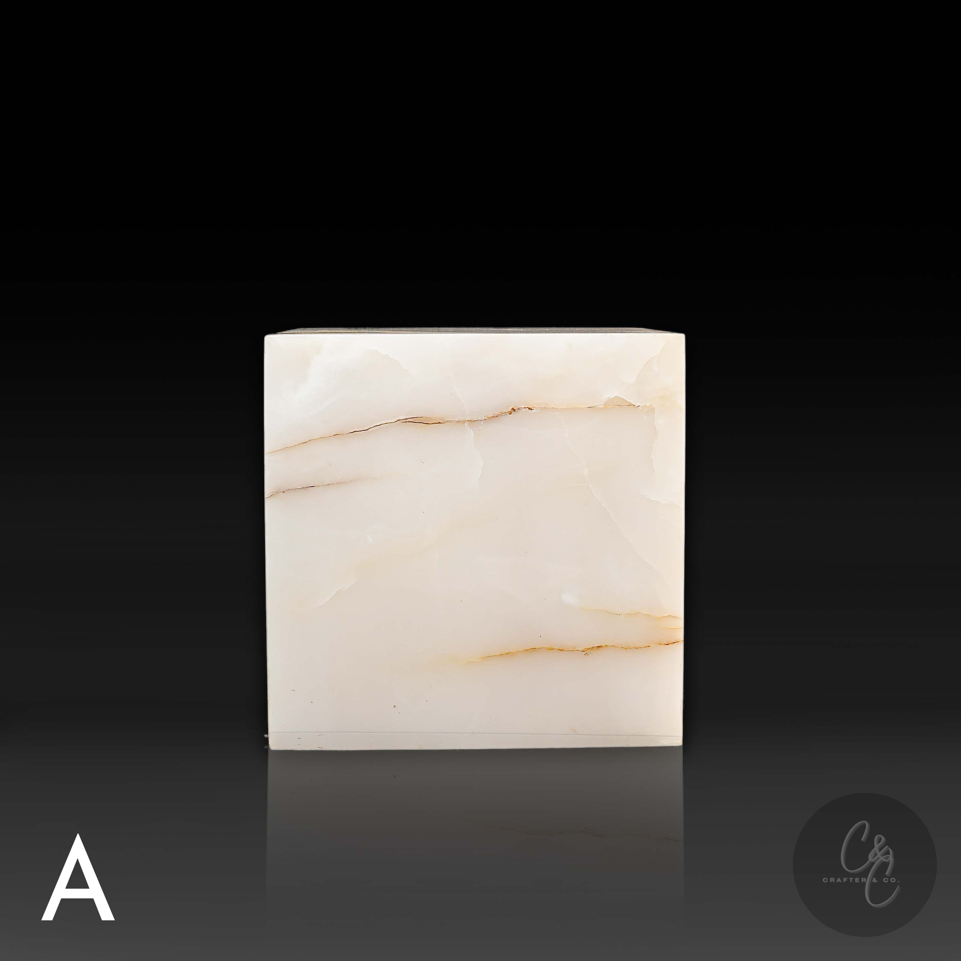 White onyx cube side table variation A shown from the front, featuring distinctive natural golden veining.