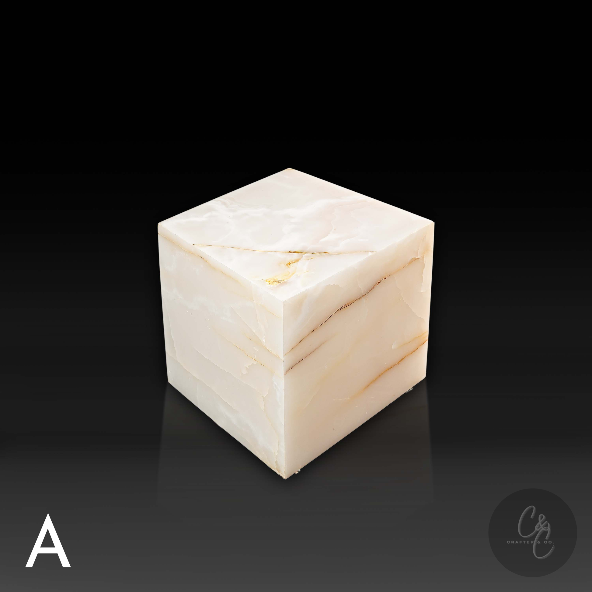 White onyx cube side table variation A shown from the front profile, highlighting its translucent stone and natural veining.
